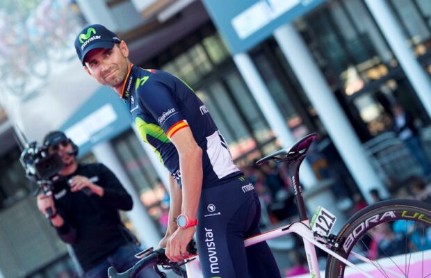 Alejandro Valverde podczas Giro d'Italia. Hiszpan stoi przy rowerze i ogląda się na kolegów z ekipy.