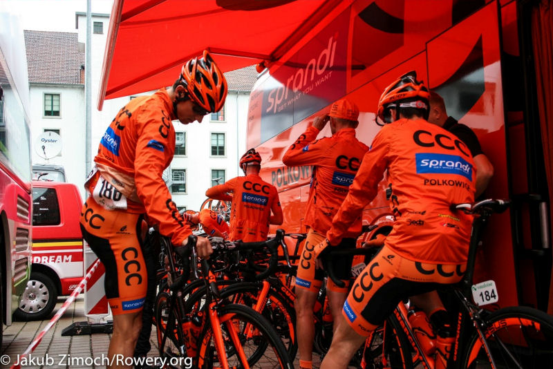 Kolarze CCC Sprandi Polkowice przygotowują się do startu etapu Tour de Suisse pod plandeką zespołowego autobusu