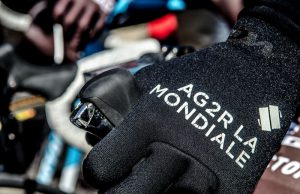 Dłoń na kierownicy w rękawiczce grupy Ag2r la Mondiale