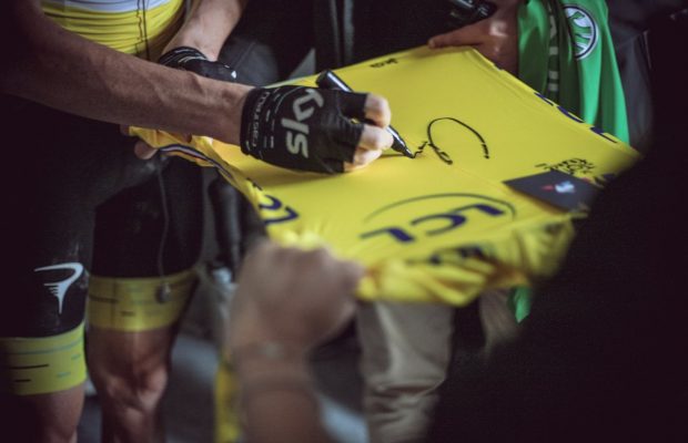Chris Froome skłda podpis na żółtej koszulce TdF