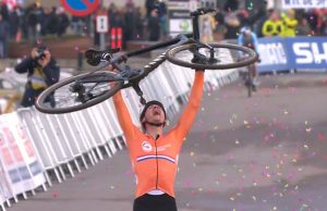 Mathieu van der Poel na mecie mistrzostw świata z rowerem podniesionym w geście zwycięstwa