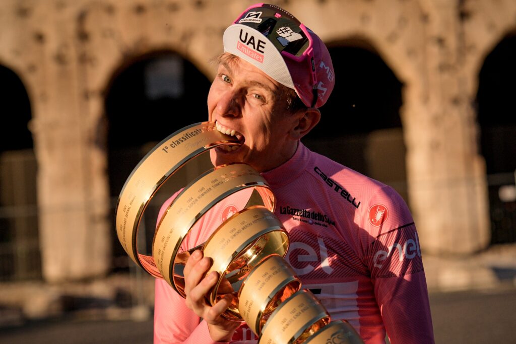 Tadej Pogacar nadgryzający puchar za zwycięstwo w Giro d'talia 2024